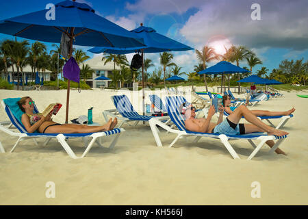 Gli adolescenti leggere sulla spiaggia, Treasure Cay, abacos, BAHAMAS Foto Stock