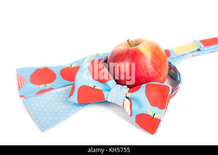 Divertenti bow tie con big red polka dots di fronte red apple, vicino, frutta fresca Foto Stock
