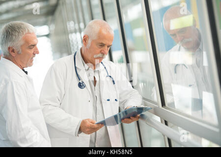 Senior medici a parlare con un infermiere Foto Stock