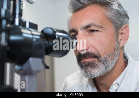 Oculista esaminando gli occhi di donna con moderne attrezzature Foto Stock
