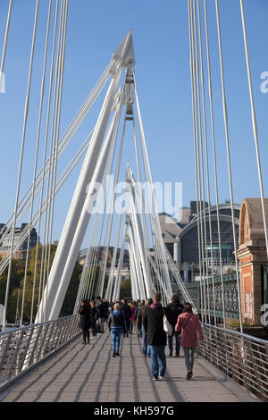 La gente camminare attraverso il Golden Jubilee Bridge, Londra Foto Stock