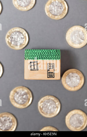 Modello di casa con monete. home concetto di finanza Foto Stock