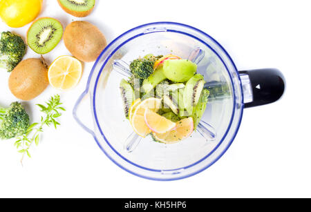 Kiwi e frutti di colore arancione in un frullatore per realizzare un smoothie Foto Stock
