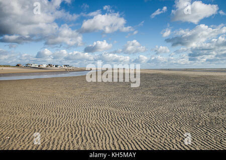 Soffiatura di sabbia lungo la spiaggia con la bassa marea - Camber Sands, East Sussex, Inghilterra Foto Stock