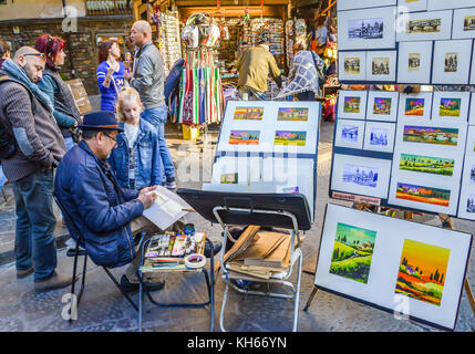 Artista di strada a Firenze, Italia produce e vende acquerelli vicino a ponte vecchio Foto Stock