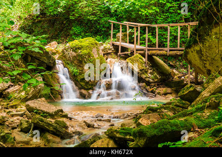 Cascata, piccolo lago e ponte nel burrone chudo-krasotka nel giorno di estate, Sochi, Russia Foto Stock