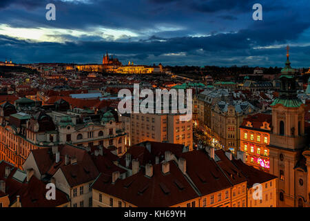 Sul tetto vista serale di tipici edifici della città vecchia e il castello di Praga sullo sfondo. Foto Stock