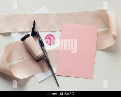 Vuoto, rosa pallido card, perfetto per matrimoni cancelleria o il giorno di San Valentino card. Busta sigillata con timbro di cera. Vista dall'alto in basso. Foto Stock