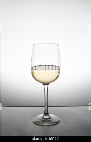 Spruzzare con il vino bianco in un bicchiere Foto Stock