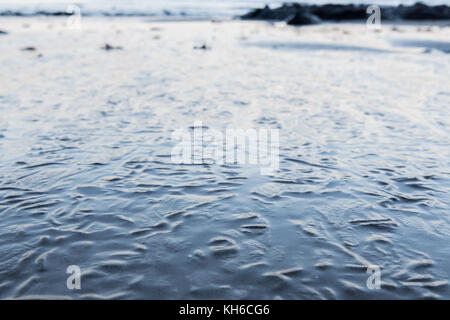 Close up di rughe in superficie sabbiosa dalla marea sfuggente Foto Stock