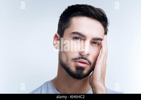 Uomo stanco di toccare la sua testa mentre con un mal di testa Foto Stock