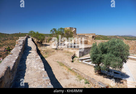 La vista di un muro di fortezza e il cortile interno del castello di mertola con la torre carouche sullo sfondo. mertola. Portogallo Foto Stock