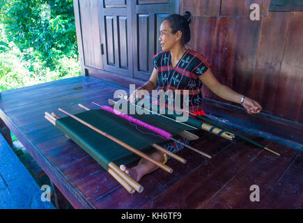 Una donna dalla minoranza Cotu si intreccia con una fascetta telaio in Quang Nam Vietnam Foto Stock