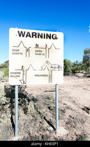 Segnale di sicurezza avvertimento contro gli alberi aperto e attività mineraria, Lightning Ridge, New South Wales, NSW, Australia Foto Stock