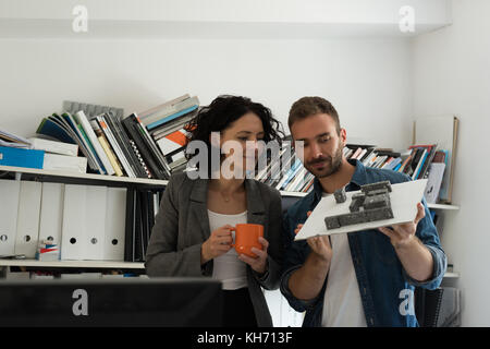 Maschio e femmina di architetti che lavorano insieme in ufficio Foto Stock