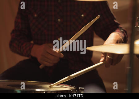 La sezione centrale del batterista giocando sul drum set in studio Foto Stock