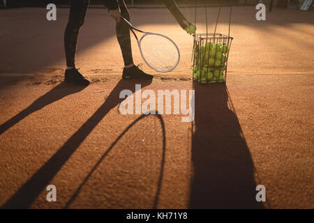 Giocatore di tennis praticare tennis in terra in una giornata di sole Foto Stock