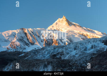 Bellissima vista della coperta di neve montagna a sunrise colorati in Nepal. Paesaggio con cime innevate delle montagne himalayane, ghiacciaio e cielo blu in m Foto Stock