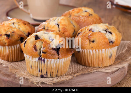 Gruppo di muffin ai mirtilli su un tagliere di legno Foto Stock