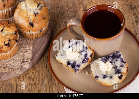 Tagliate a fette muffin ai mirtilli e burro con una tazza di caffè Foto Stock