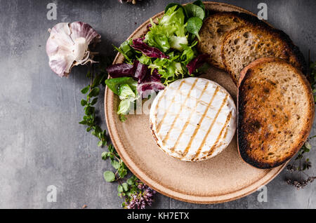 Grigliata di formaggio camembert, mini insalata e pane cotto Foto Stock