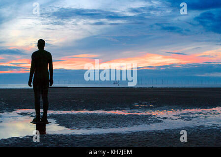 Crosby, Merseyside. Il 14 novembre 2017. Regno Unito Meteo. Dopo un opaco e Grigio per giorno nel nord-ovest dell'Inghilterra, un tramonto tenta di rompere attraverso le nuvole sopra Sir Antony Gormley "Uomini di Ferro' arte di installazione a Crosby nel Merseyside. Credito: Cernan Elias/Alamy Live News Foto Stock