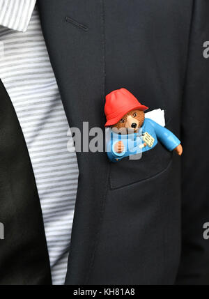 Un uomo che arriva per un servizio memoriale per l'autore di Paddington Michael Bond a St Paul&acirc; la Cattedrale di™, Londra, con un orso di Paddington nella tasca della sua tuta. Foto Stock