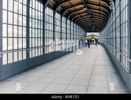 Germania Berlino,Friedrichstrasse stazione ferroviaria building interior,persone a piedi nel centro storico di vetro e acciaio passaggio di uscita Foto Stock