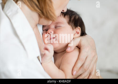 La mamma mentre tiene il suo bambino figlia. baby è addormentato nella madre di braccia Foto Stock