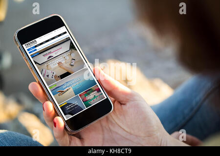 Vista ravvicinata della giovane donna navigare in internet con il suo telefono cellulare. Tutti i grafici dello schermo sono costituiti. Foto Stock