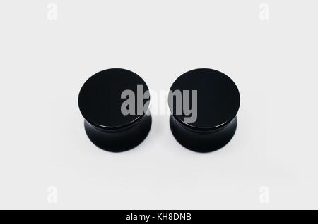 Coppia di nero tappi ear piercing, orecchio barelle. Foto Stock