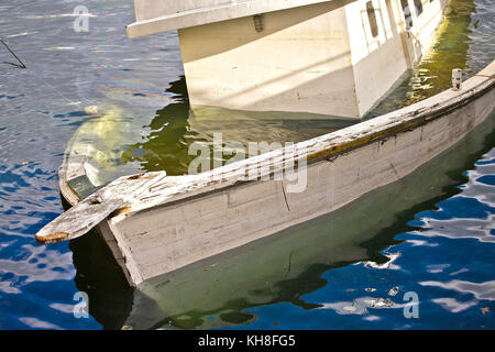 Piccola barca che affonda in acqua Foto Stock