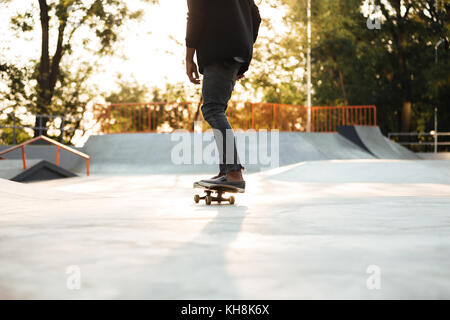 Giovane guidatore di skateboard su skateboard a Sunset City Park Foto Stock