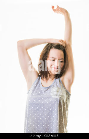 Una giovane ragazza caucasica dai capelli castani che indossa pimarmellate, che sembra stanca assonnata e stanca, pronta per andare a letto Foto Stock