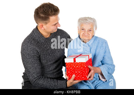 Immagine di una vecchia signora ricevere regali di compleanno da suo nipote Foto Stock
