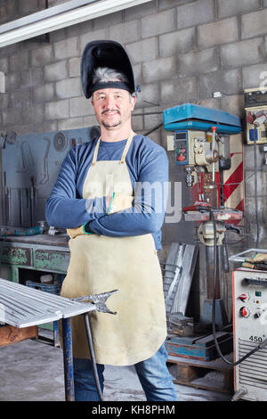 L'uomo come saldatore e carpentiere metallico con esperienza nel laboratorio di metallurgia Foto Stock