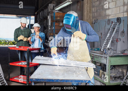 Saldatore processo metallurgico in metallurgia fabbrica con collare blu lavoratore Foto Stock