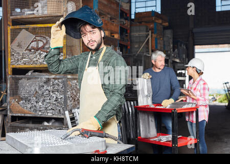 Saldatore giovane uomo nel workshop di settore come carpentiere metallico Foto Stock