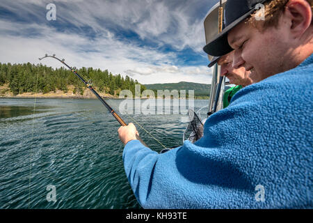 Due uomini, padre e figlio, con canna da pesca, su una barca da pesca nello stretto di Johnstone al largo dell'isola di Vancouver, British Columbia, Canada Foto Stock