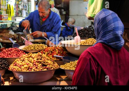 Fez, in Marocco - 8 novembre 2017: musulmana lady acquisto di olive a La medina di Fez mercato. Foto Stock