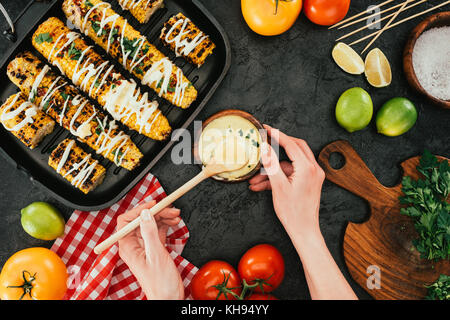 Donna con tazza di salsa e mais Foto Stock