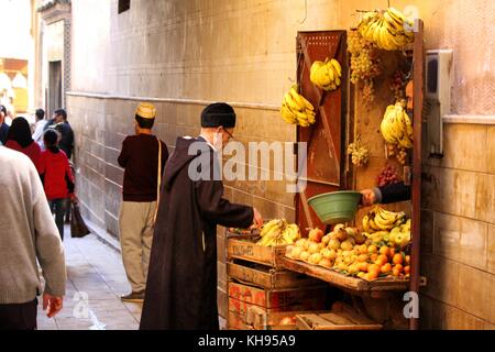 Fez, Morrocco - 8 Novembre 2017: persone locali acquisto di merci in una strada mercato di frutta e verdura in Fez Medina Foto Stock