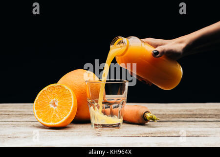 Donna versando del succo di frutta fresco nel vetro Foto Stock