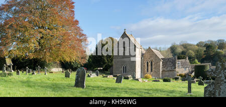 La Chiesa di San Pietro e il sagrato della chiesa nel villaggio di Duntisbourne abbots in autunno. Cotswolds, Gloucestershire, UK. Vista panoramica Foto Stock