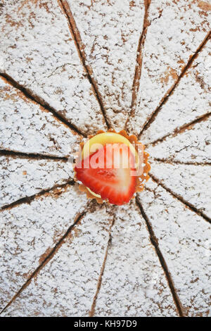 Primo piano, vista dall'alto di una fragola seduta su una torta al cioccolato - John Gollop Foto Stock