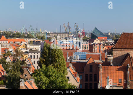 Gli edifici di vecchia costruzione presso le principali città (città vecchia) e del cantiere navale gru da carico lontano in Gdansk, Polonia, visto dal di sopra in una giornata di sole. Foto Stock