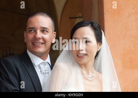 Interracial wedding, Italia. Felice sposa cinesi e caucasico sposo per celebrare il loro amore giorno Foto Stock