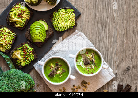 Vegetariano cibo sano. Zuppa e vegane panini. diversi panini con avocado. brunch il bianco sullo sfondo di legno Foto Stock