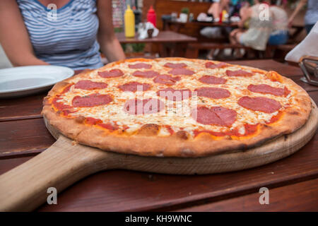 Pizza su una tavola di legno. Foto Stock