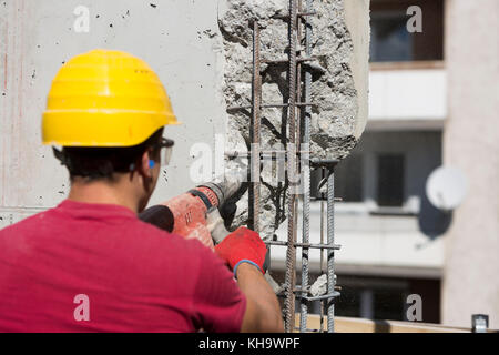 Operaio edile utilizzando una testa di foratura power tool. Foto Stock